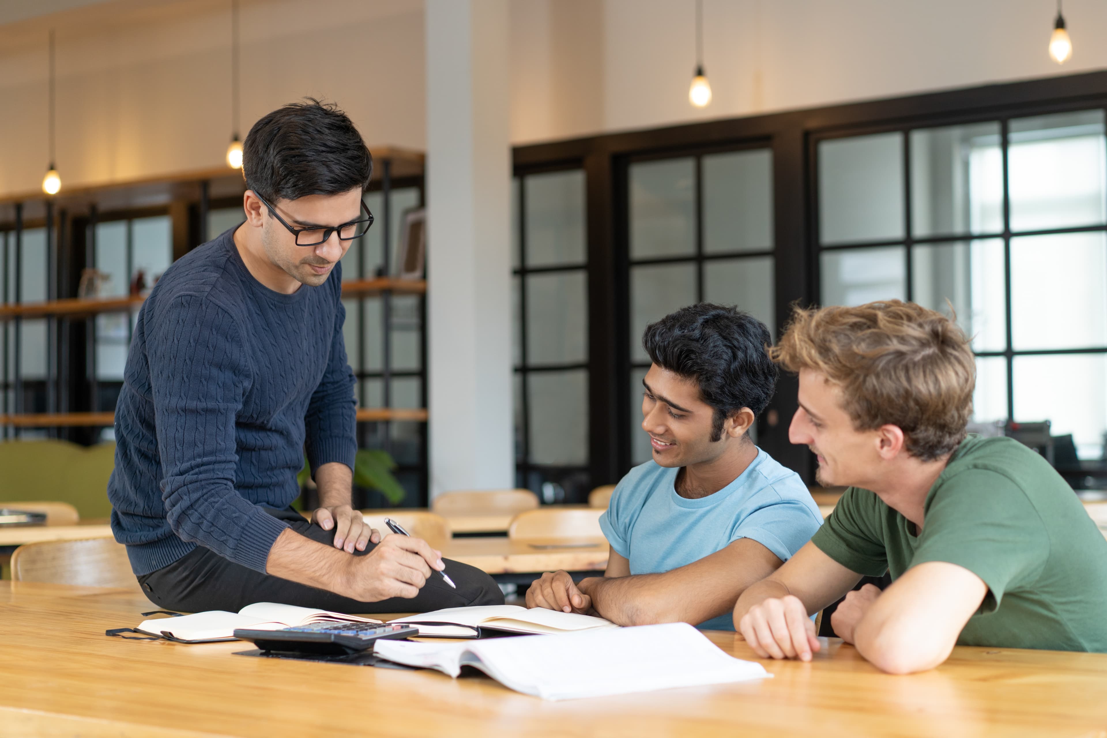 A counsellor guiding two students through their application documents